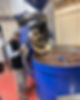 Man standing beside large industrial coffee roasting machine