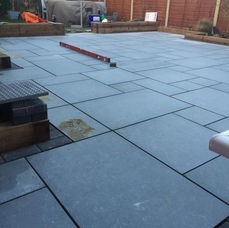 Large patio of dark gray paving slabs
