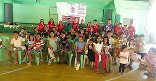 A group of smiling children sitting on green chairs