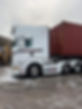 A white Scania truck with a red shipping container attached, being washed with a pressure washer