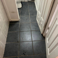 Bathroom floor with large, dark gray tiles