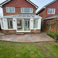 Patio paving installation next to a brick house and conservatory