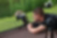 A photographer lies on the ground with a camera and tripod to photograph a goose