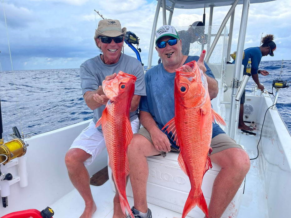 Guy Holding Red snapper in a boat Placencia, Belize