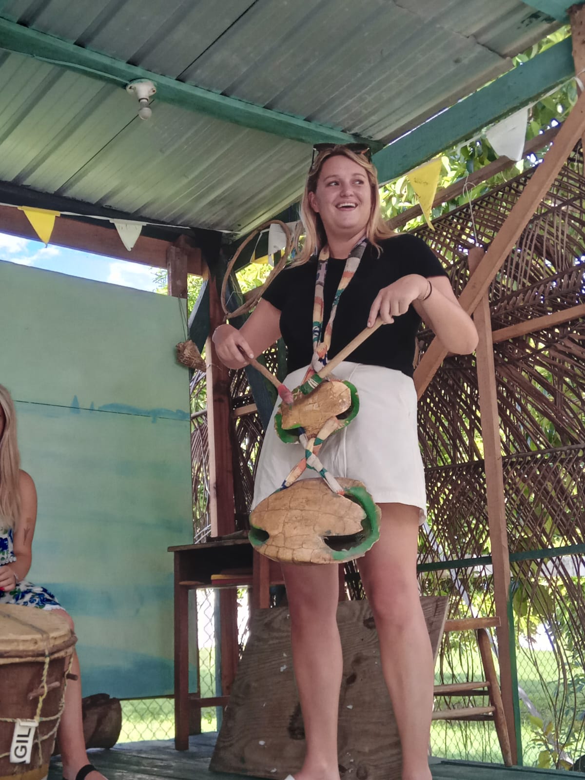 a woman playing turtle shellswhich is a musical instrument of the Garifuna people