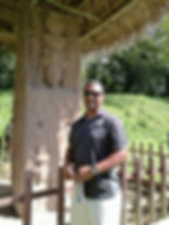 Arthur Westby smiling standing in front of a Mayan artifact in Belize