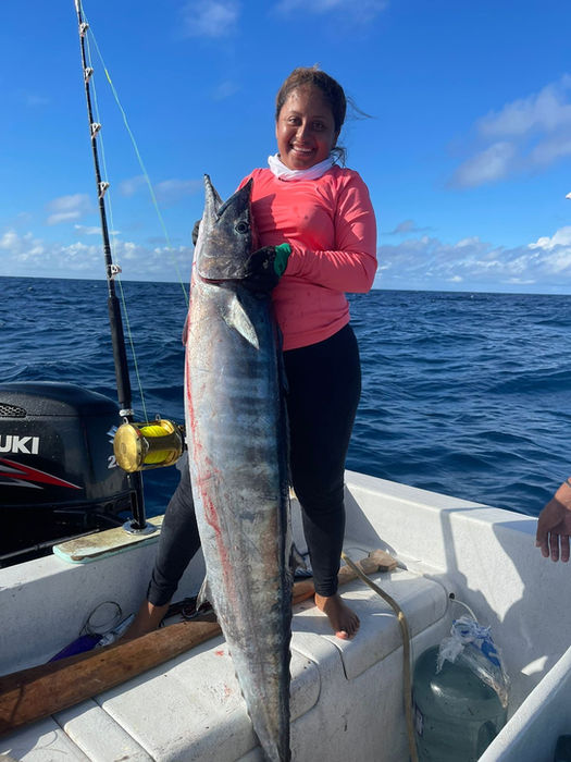 woman holding Barracuda fish in a boat Placencia