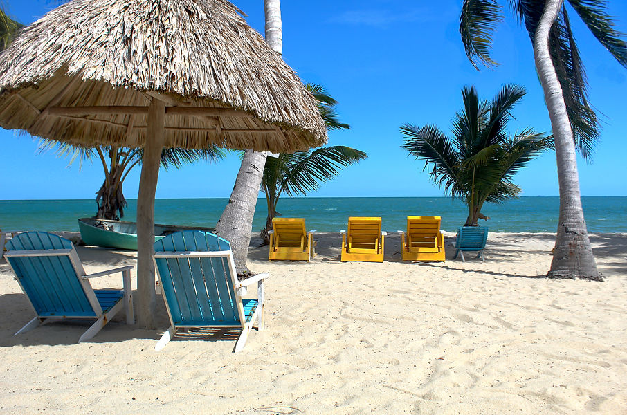 Palapa with two chairs and other beach chairs on beach of Sea Spray Hotel in Placencia