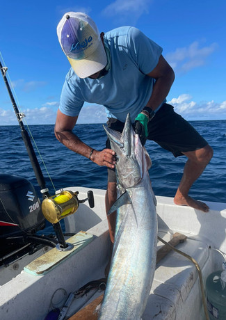 Man holding barracuda fish in a boat Placencia