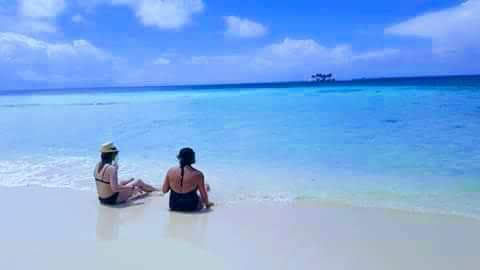 two women sitting on beach in Belize