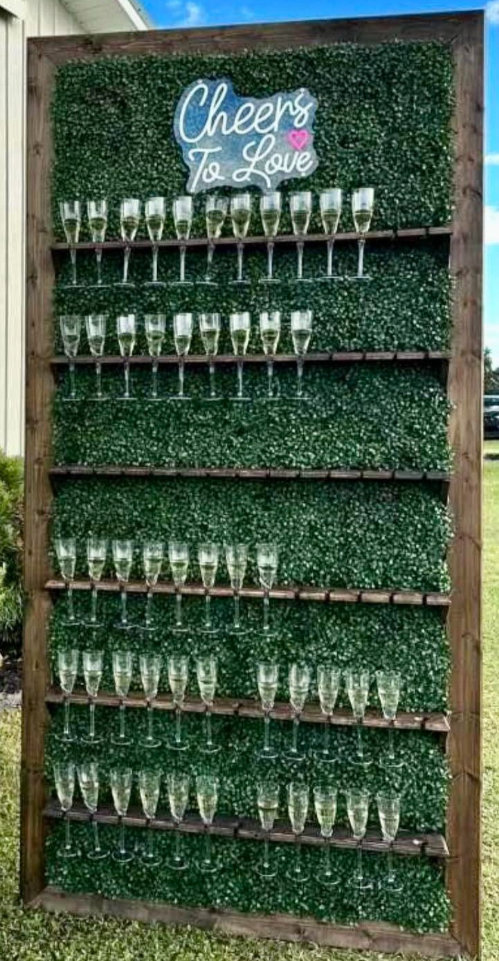 Thumbnail: Champagne glasses displayed on a greenery wall with the text 'Cheers to Love'.