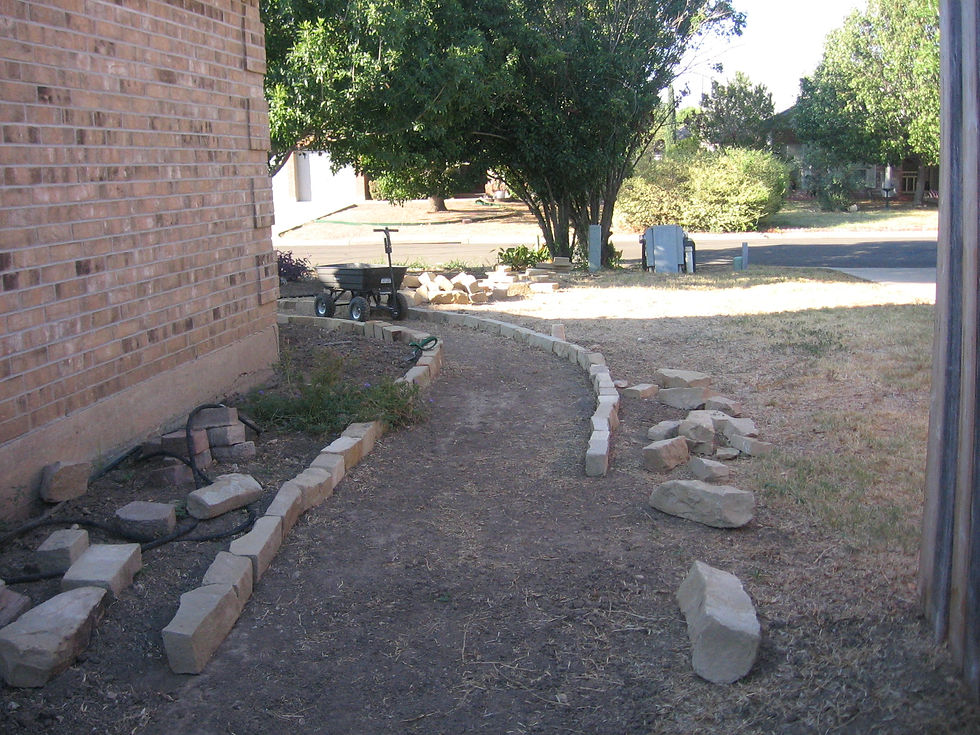 Coming around from the front. You can see a pile of rock by the wheelbarrow and others laying on the ground. I made several trips to the landscape supply and bought clearance. Path was close to halfway complete.
