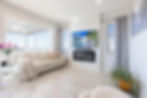 Bright modern living room with sofa, TV, and large window