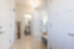 Bright hallway with white doors and bathroom view