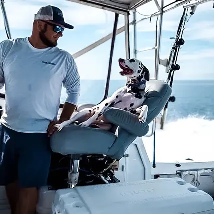 Ryan from Instigator fishing and diving charters in the captains cabin with his dog enjoying a beautiful day in North Carolina