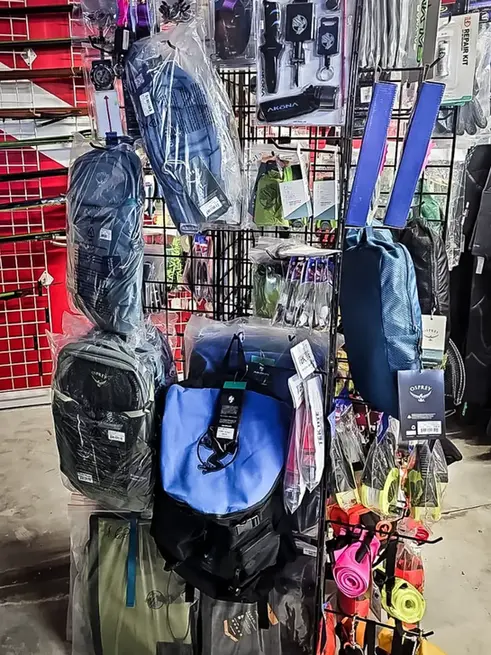 Instigator fishing and diving retail shop rack featuring assorted kits, dry bags, SMBs, leashes and compasses
