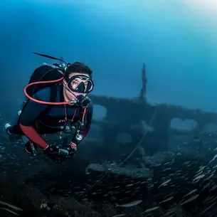 diver underwater in front of a sunken ship wreck in the atlantic of North Carolina