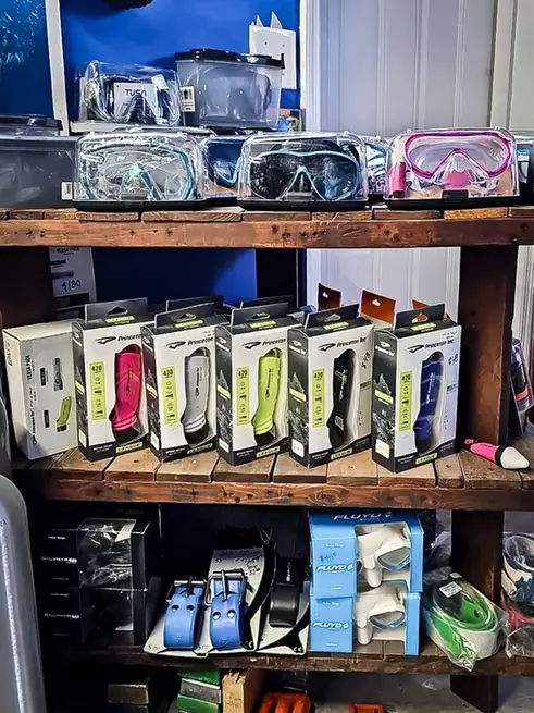 Instigator fishing and diving retail shop with dive masks, weights, weight belts and Princeton Tec League 420 torches on display