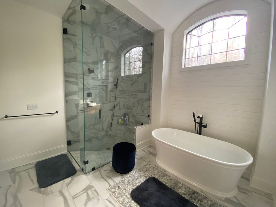 Tiled bathroom floor and tub surround by Lino's Flooring