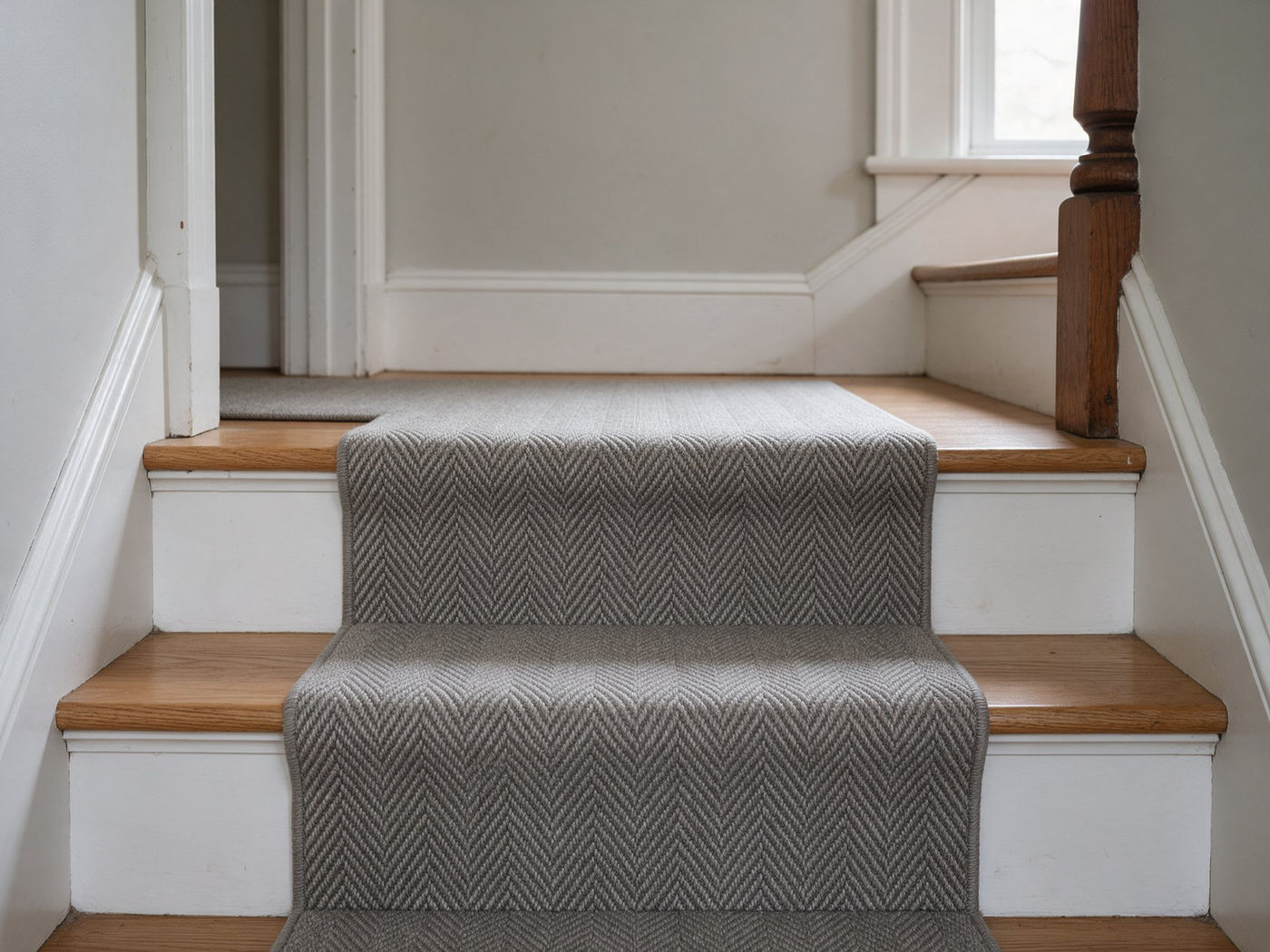 Herringbone carpet runner wrapped over oak stair treads — illustrative image