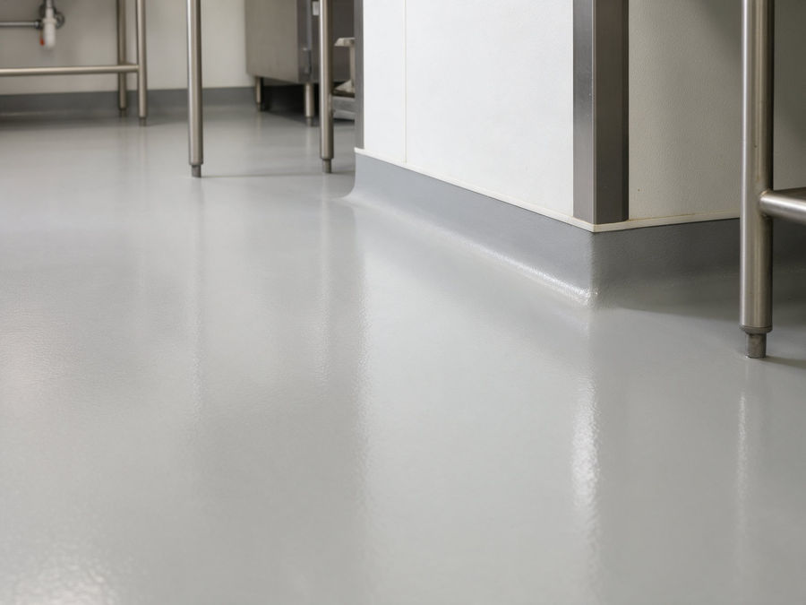 Seamless grey epoxy floor with coved base in a commercial space — illustrative image
