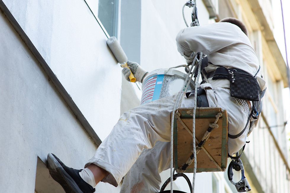 builder climber paints facade building