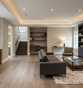 Spacious basement with gray sofa in toronto