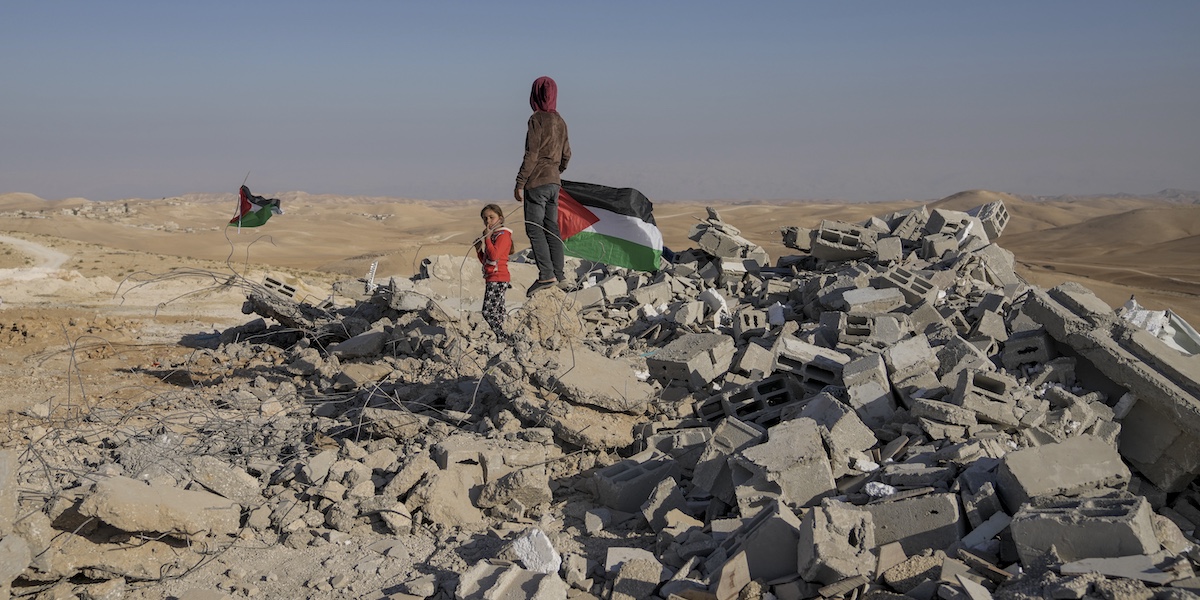 Palestinesi sulle macerie di una scuola demolita dall'esercito israeliano a Masafer Yatta, nel 2022 (AP Photo/Mahmoud Illean)
