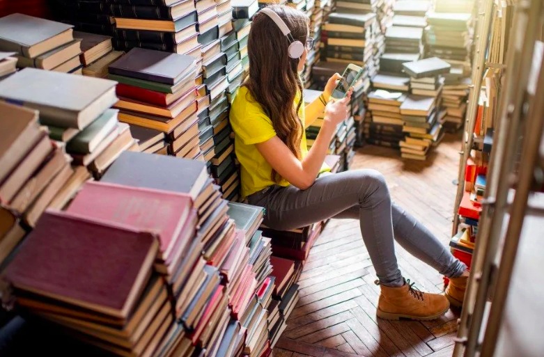 Una ragazza che preferisce "scrollare" sui social piuttosto che scegliere un libro e leggerlo.