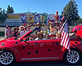 Decorated Red VW Bug with American Flag and Garden Club Members in 4th of July Parade