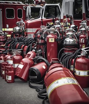 A squad of fire engines, firefighting gear, and fire extinguishers all prepped for a blazi