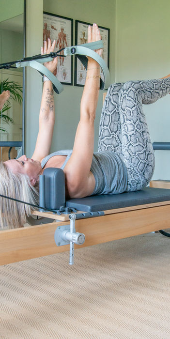 Woman doing Pilates exercise on reformer machine at Lisa Pilates