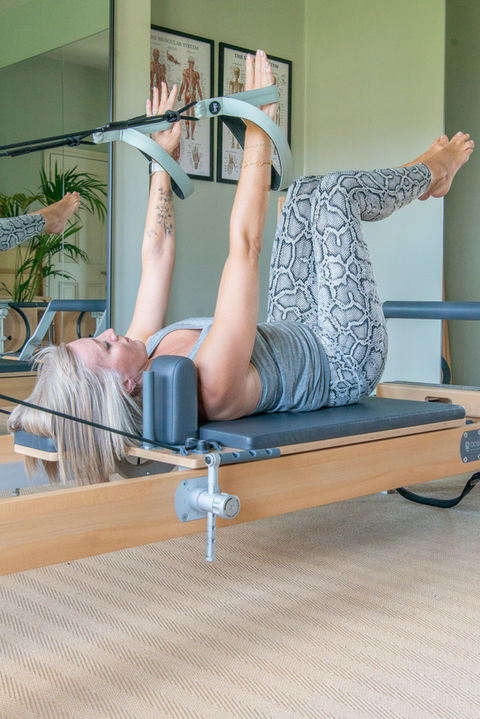 Woman doing Pilates exercise on reformer machine at Lisa Pilates