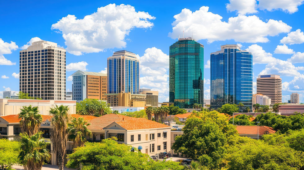 Downtown skyline with modern office buildings under a bright blue sky.