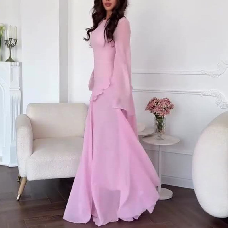 Thumbnail: Woman in a long, flowing light pink dress with bell sleeves