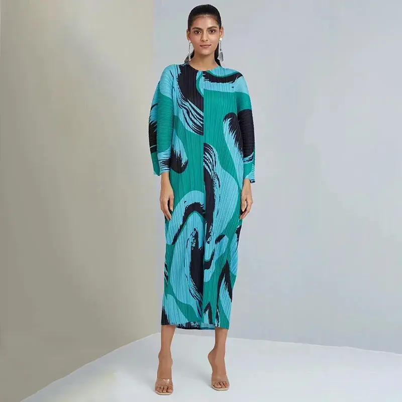 Thumbnail: Woman in abstract green and blue patterned long dress