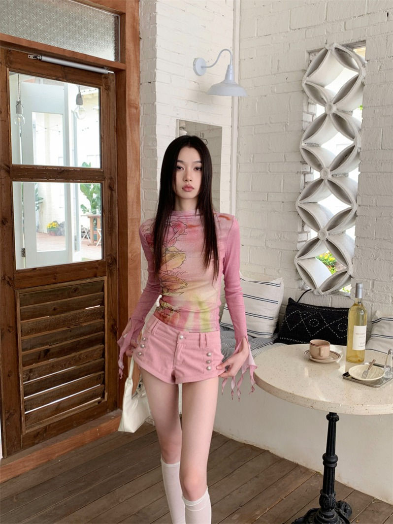 Woman in patterned long-sleeve top and pink shorts
