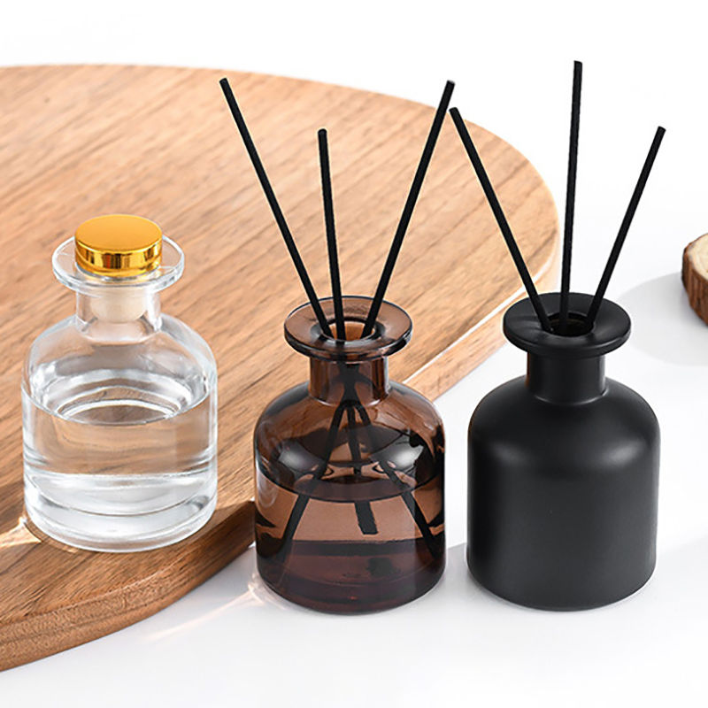 Clear, amber, and black diffuser bottles with reeds