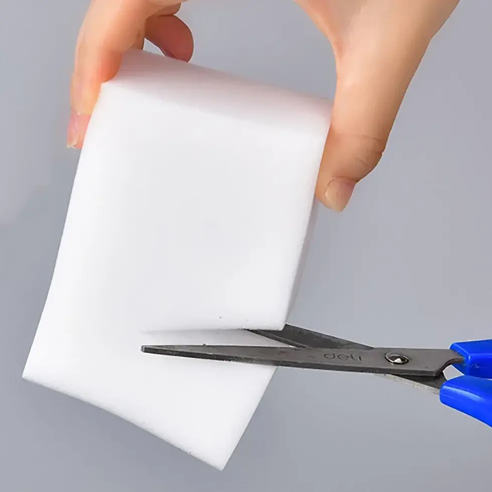 Thumbnail: Hand cutting white cleaning sponge with scissors