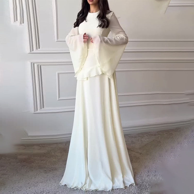 Woman in a long cream dress with flowing sleeves