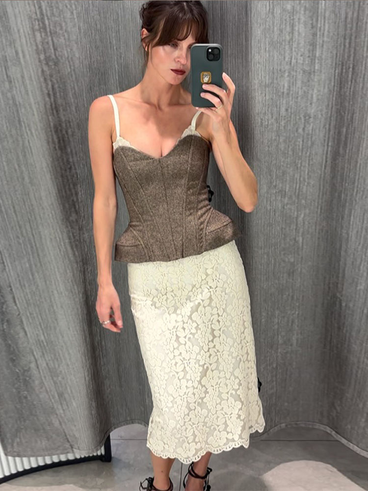 Woman taking selfie in brown corset top and lace skirt
