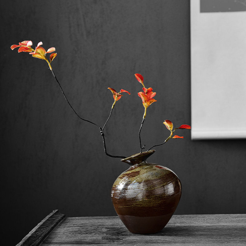 Brown vase with delicate orange-red flowers