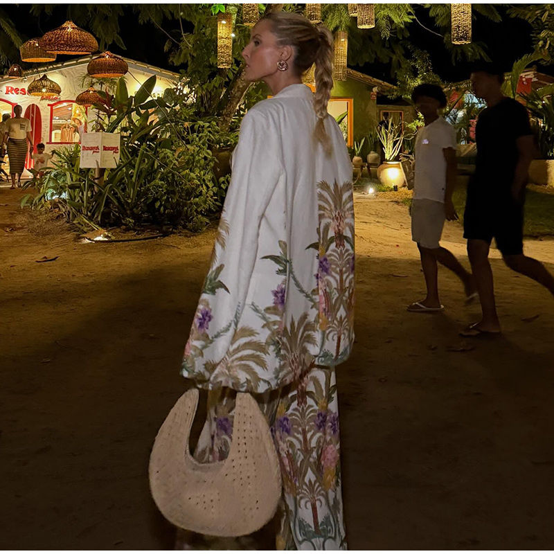 Thumbnail: Woman in patterned kimono and pants holding a woven bag