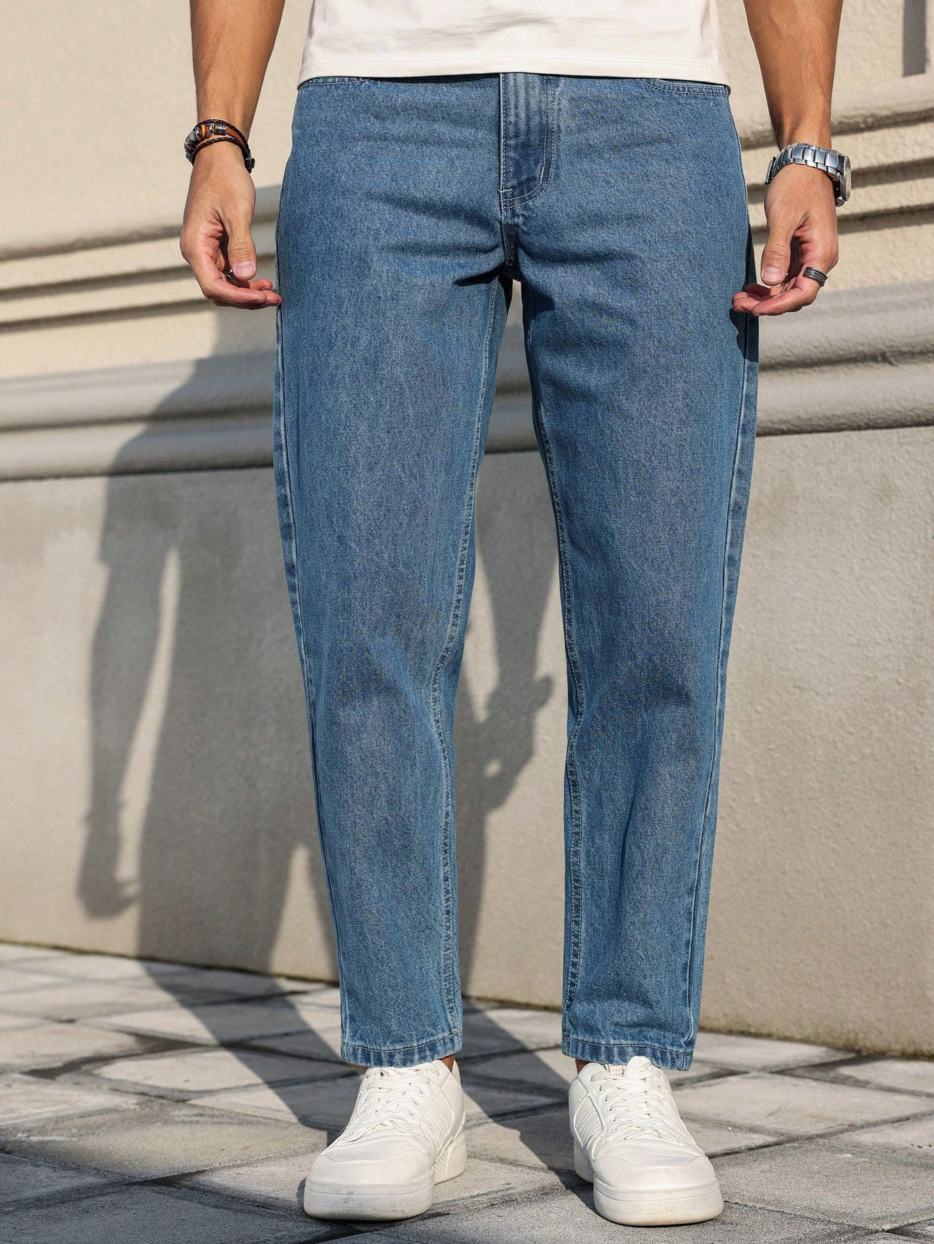 Men's jeans are made of classic blue denim fabric with a loose fit, making them 