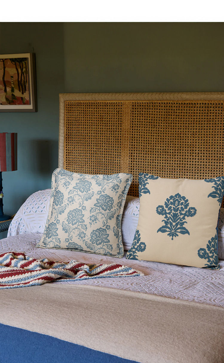 Thumbnail: Two beige and blue patterned cushions on a bed