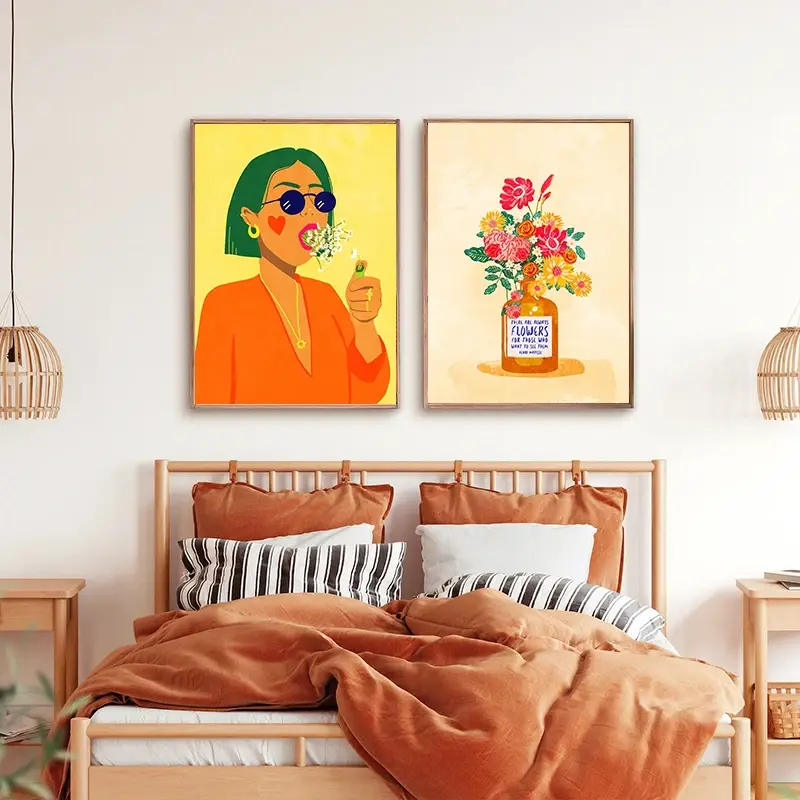 Thumbnail: Two colorful abstract wall art prints, one of a woman blowing bubblegum, the other of flowers in a vase, above a bed.