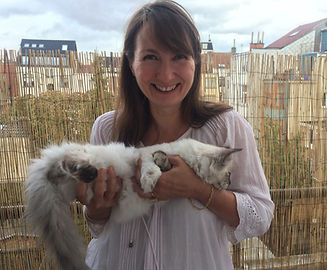 Femme qui sourit avec un chat sibérien dans les bras