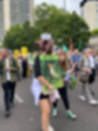 A girl is marching down a london street holding a placard which reads 'Ban Snares' her friend is next to her and holds a placard against factory farming