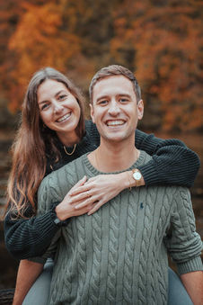 Pärchen lacht in die Kamera bei einem Herbstshooting 