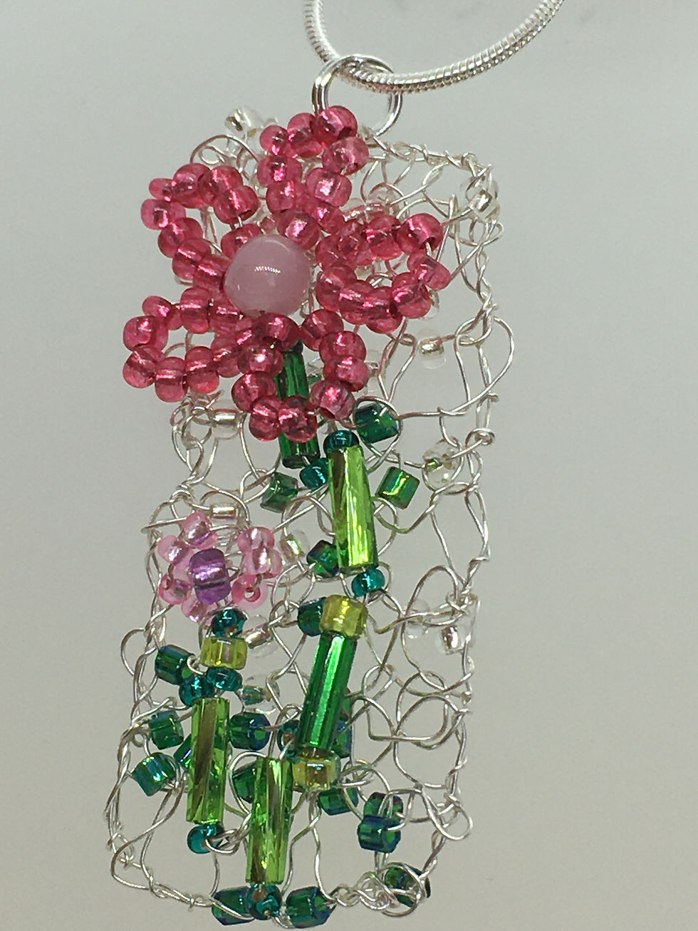 Knitted pink flower pendant